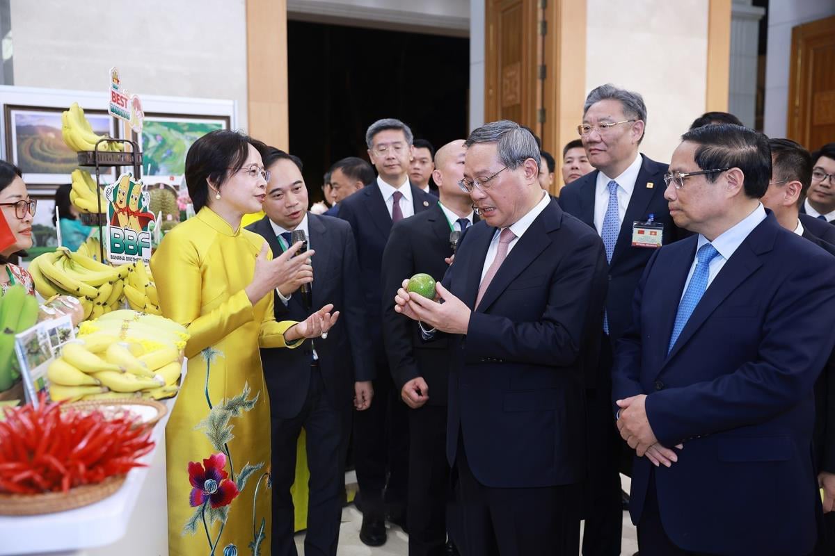 Thủ tướng Phạm Minh Chính và Thủ tướng Trung Quốc Lý Cường thăm gian hàng trưng bày nông sản. Ảnh: TTXVN.