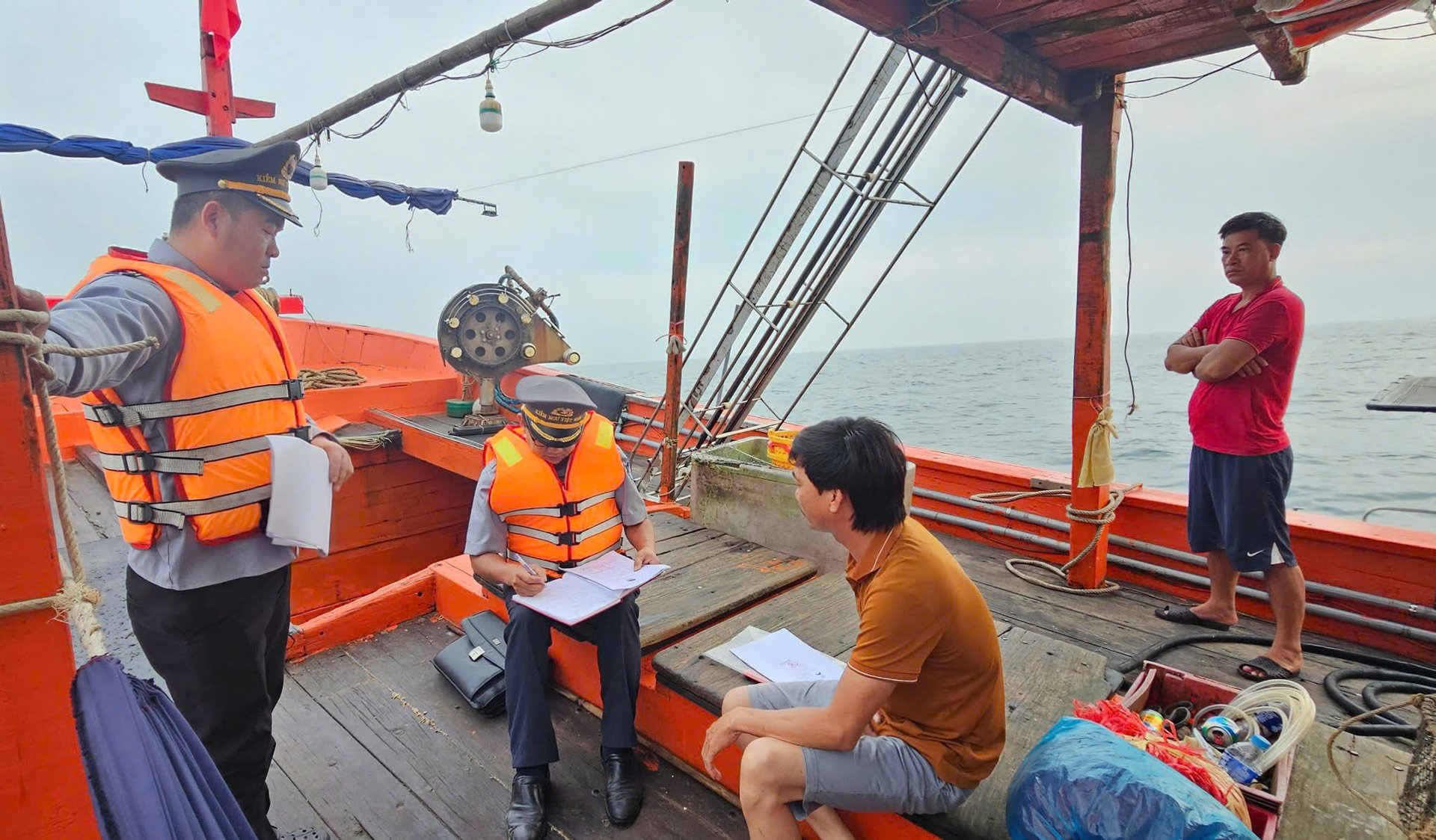 Tổ công tác lập biên bản việc tàu cá ngư dân vi phạm khi đánh bắt trên biển. Ảnh: T. Đức.