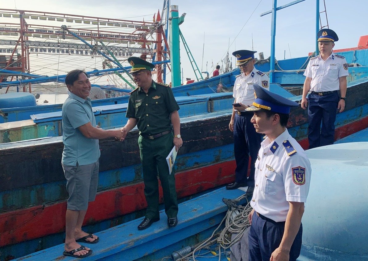 Lực lượng chức năng làm việc với chủ tàu, thuyền trưởng để hướng dẫn thủ tục cấp giấy tờ, tuyên truyền thực hiện IUU. Ảnh: Lan Anh