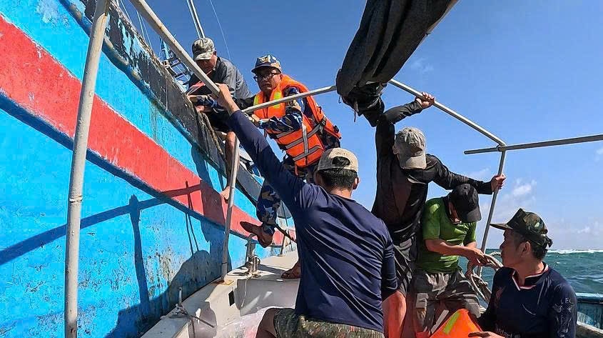 Cán bộ, chiến sĩ đưa ngư dân xuống xuồng. Ảnh: Hoa Ngọc Ánh