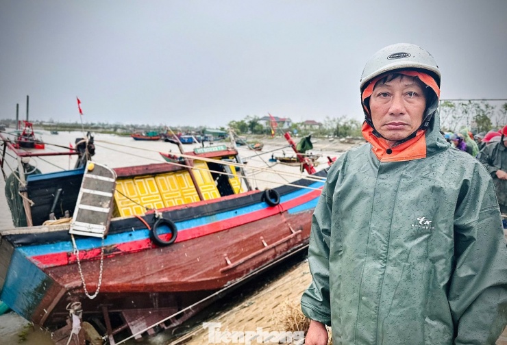 Ông Nguyễn Trọng Việt cùng con tàu nằm vắt nửa thân lên bờ kè.