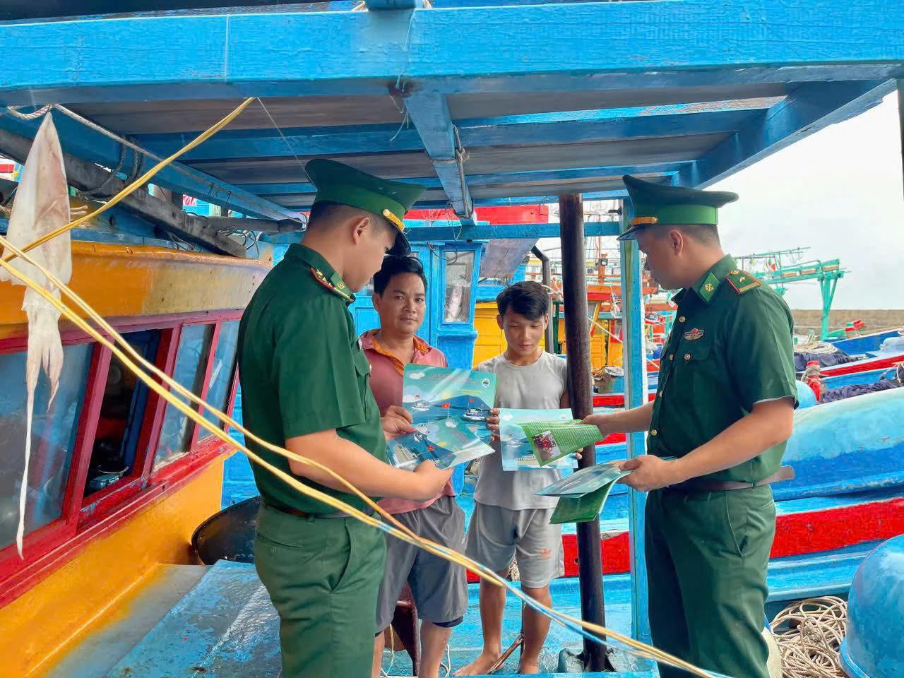 Cán bộ, chiến sĩ Đồn Biên phòng Cồn Cỏ phát tờ rơi tuyên truyền chống khai thác IUU cho ngư dân - Ảnh: Đ.V
