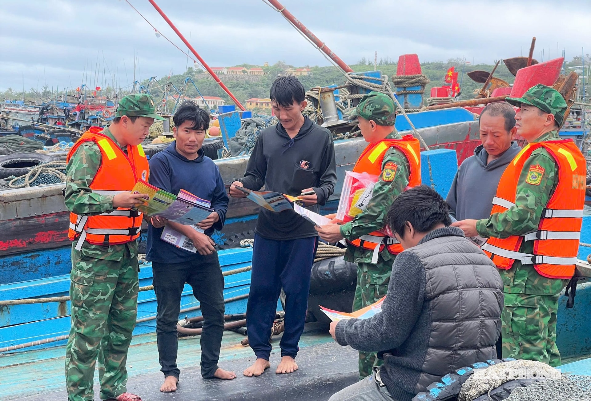 Tổ công tác của 2 đơn vị cấp phát tờ gấp tuyên truyền chống khai thác IUU cho ngư dân