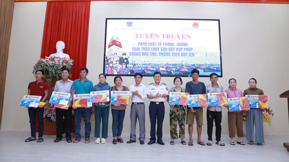 Đại tá Nguyễn Thái Dương, Phó Chính ủy BTL Vùng Cảnh sát biển 4 và ông Phan Chiến Thắng, Trưởng ban Tuyên giáo và Dân vận Đảng ủy đặc khu Phú Quốc tặng quà cho ngư dân có hoàn cảnh khó khăn. Ảnh: Quang Vinh 