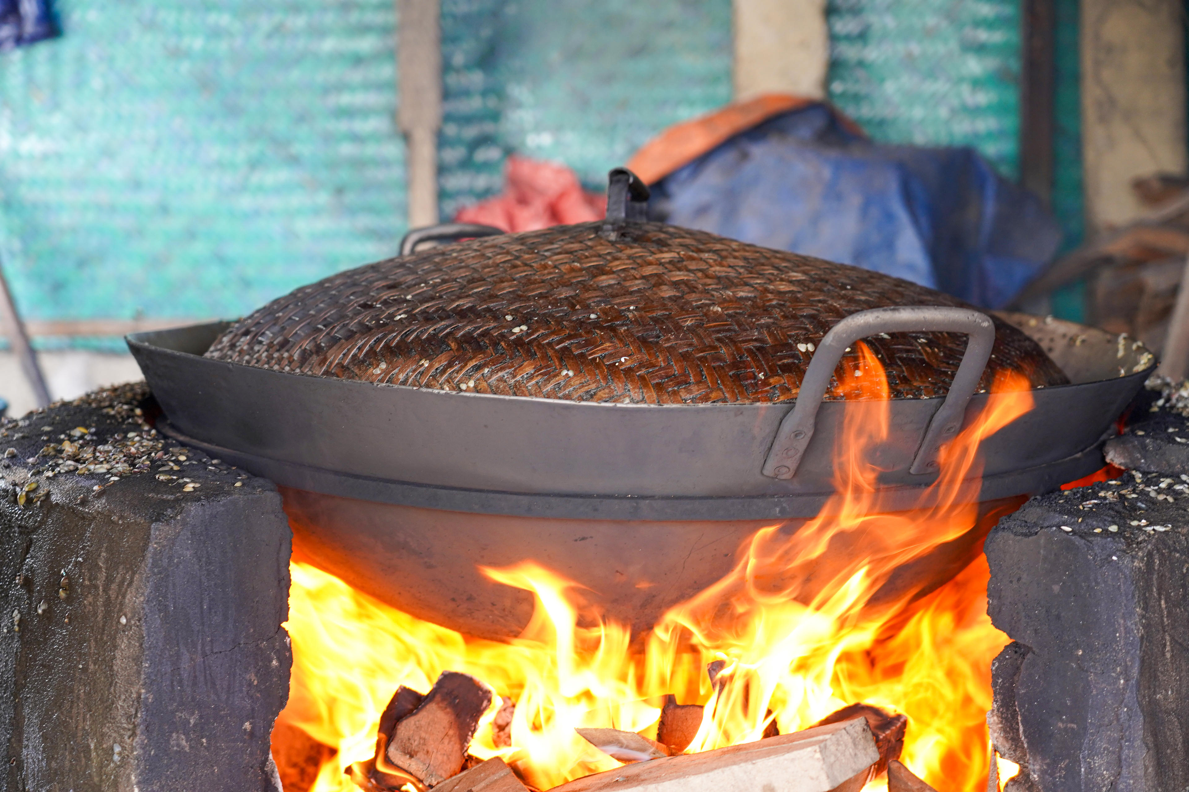 Lửa được giữ thật đều suốt khoảng 20 phút, liên tục đảo tay để hến mở miệng và tách ruột, bởi chỉ cần lửa yếu hoặc nước quá nhiều, mẻ hến sẽ không đạt độ ngọt cần thiết. Ảnh: Cẩm Kỳ 