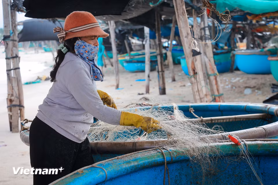 Làng cá truyền thống Vĩnh Tân: "Mặn mòi vị biển" giữa dòng chảy hiện đại Ngư dân sau mỗi chuyến thu hoạch lại tất tưởi sửa soạn những tấm lưới chuẩn bị cho những buổi ra khơi tiếp theo. (Ảnh: Hoài Nam/Vietnam+)
